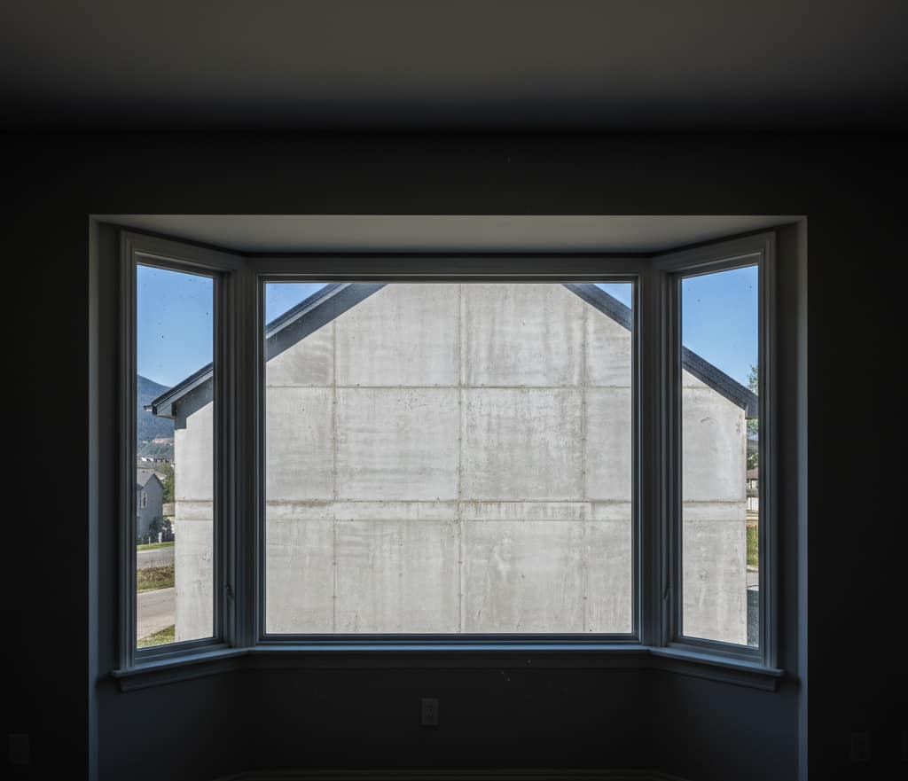 un salon sombre dont la vue est obstruée par le mur d'un nouveau voisin